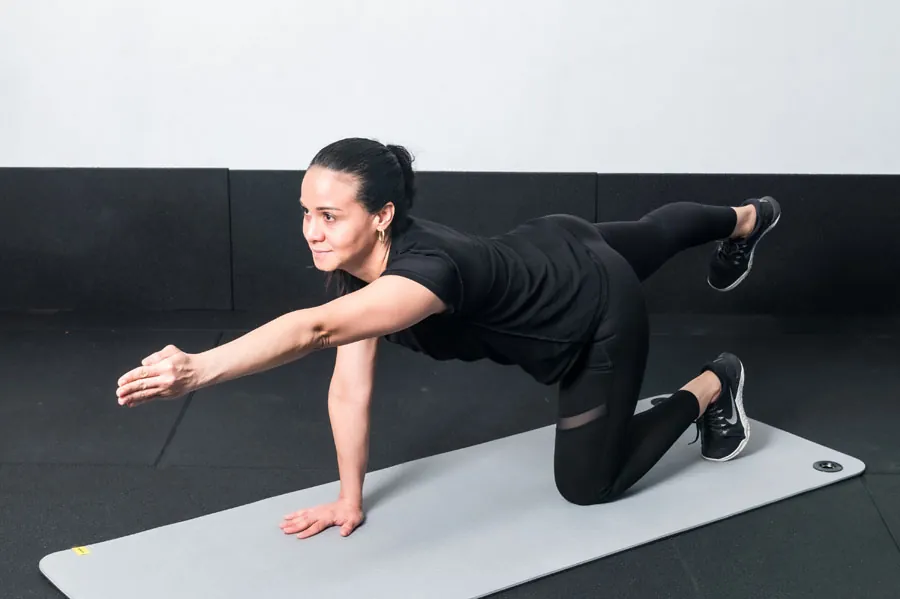 Man pausing a workout with lower back discomfort during bone density exercises