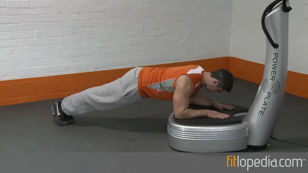 Person planking with locked elbows directly on a vibration plate machine
