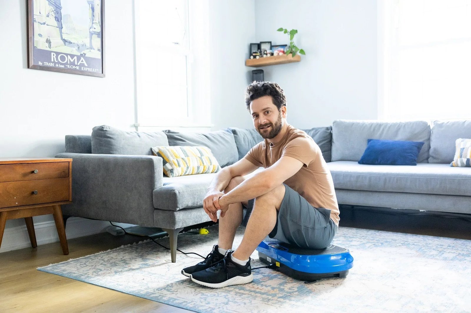 Woman balancing on a vibration plate in a bright living room