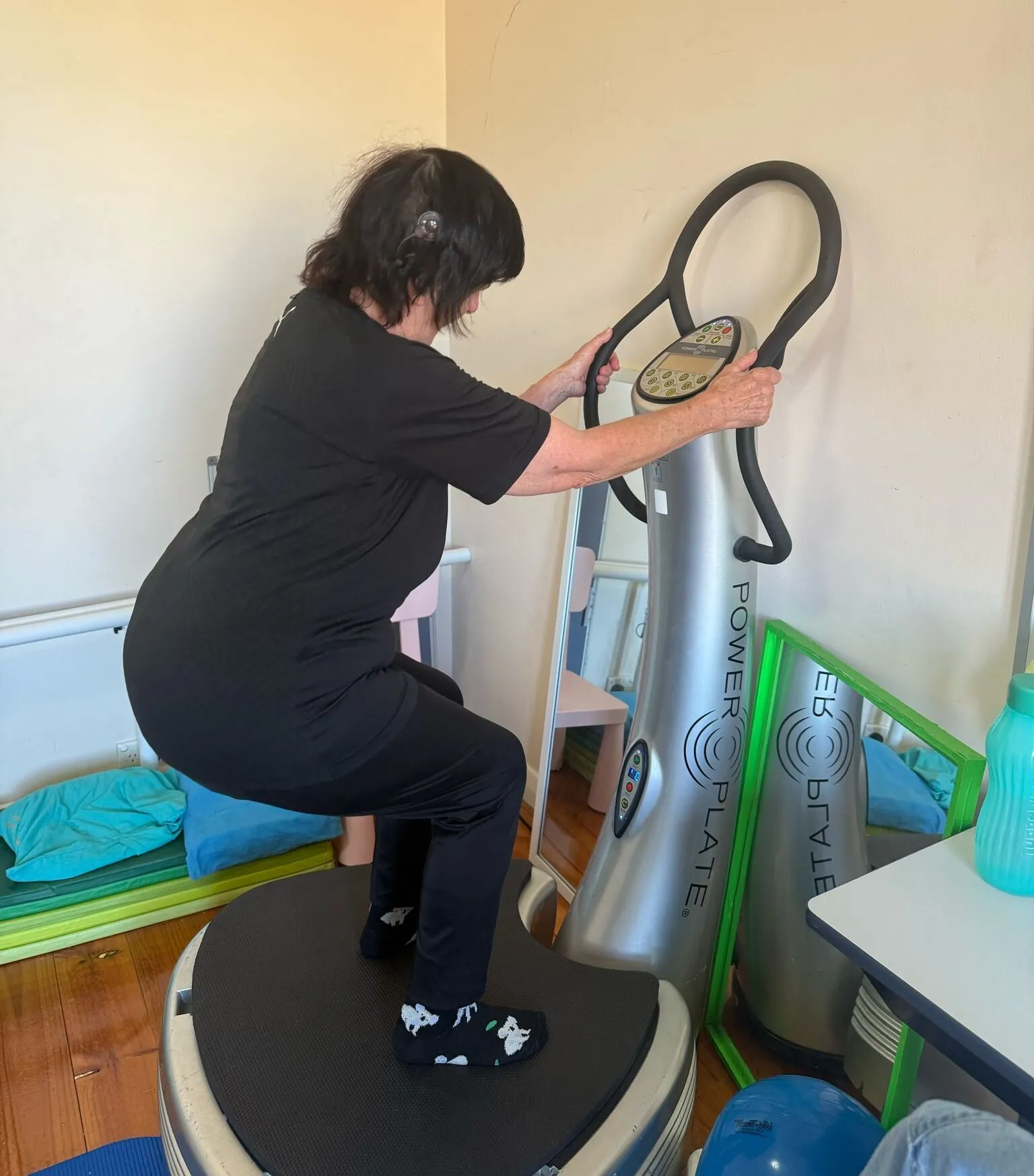 Woman checking her legs beside a vibration plate during a workout session