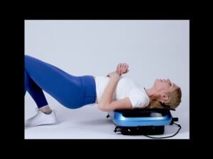 Woman lying on a vibration plate in a bright living room
